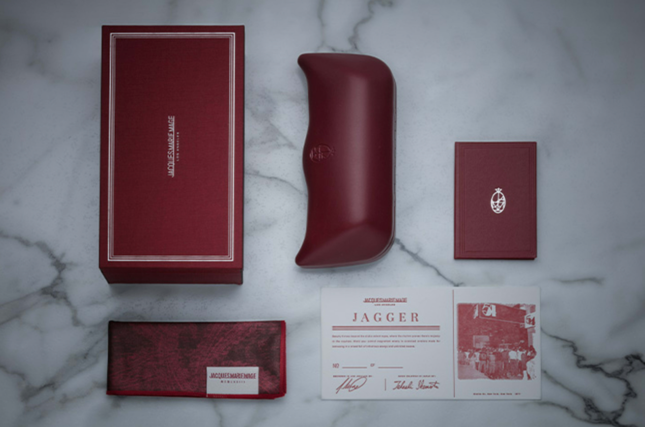 Maroon eyewear case and accessories on a marble surface