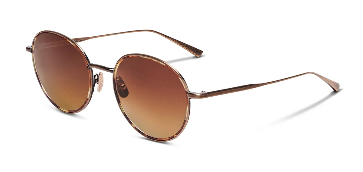 The SALT. Seine sunglasses by SALT. feature round, brown-tinted oversized lenses with thin metal frames and nose pads, displayed at an angle on a white background.