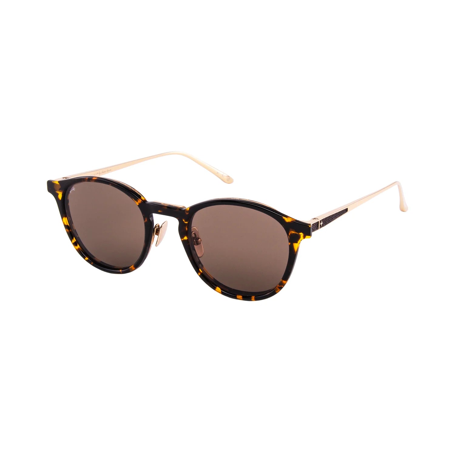 The Leisure Society Siena sunglasses by Leisure Society feature round tortoiseshell acetate frames, dark lenses, and slender, light-colored titanium arms crafted from premium materials. These luxury eyewear pieces seamlessly blend the timeless style of acetate with the contemporary sophistication of titanium. Shown against a white background.
