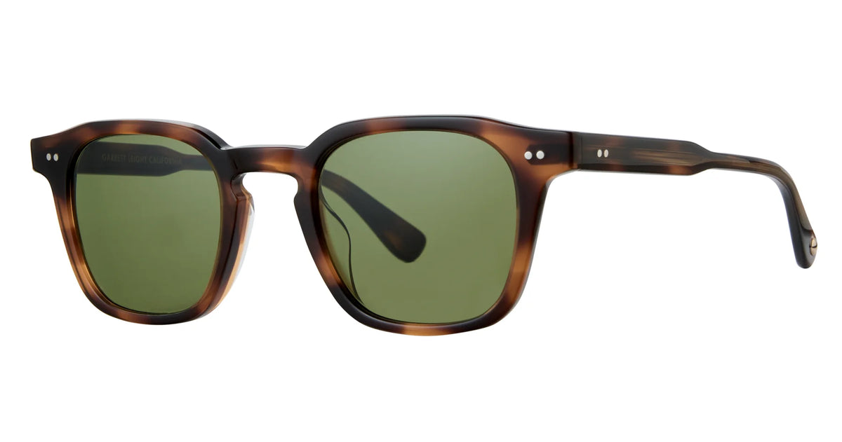 Garrett Leight Verdugo sunglasses by Garrett Leight, featuring a brown tortoiseshell rectangular frame with premium glass lenses and a keyhole bridge, offering 100% UV protection, displayed at an angle on a white background.