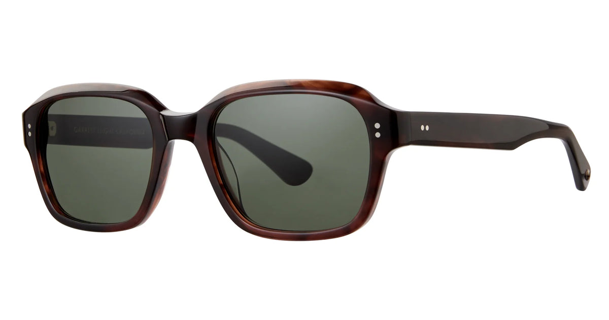 The Garrett Leight Dominguez by Garrett Leight showcases brown rectangular sunglasses with thick frames, premium glass lenses that provide UV protection, and subtle metal rivet accents near the hinges, evoking a refined vintage square sunglasses aesthetic when displayed against a white background.