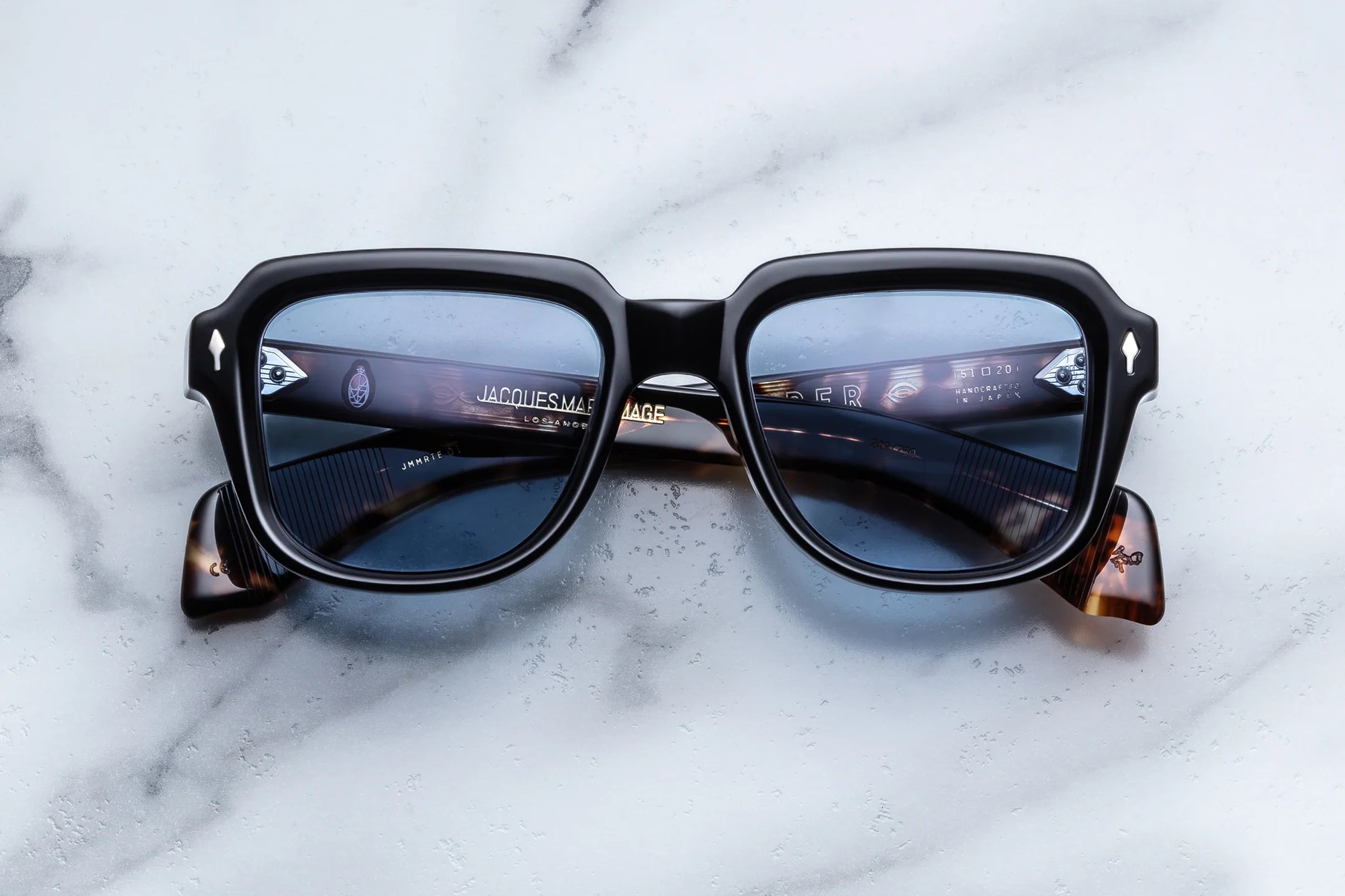 Sunglasses with reflective lenses on a marble surface
