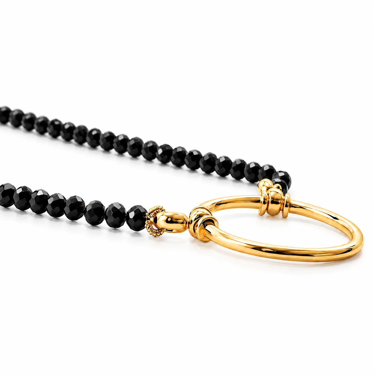 La Loop Stella necklace featuring black spinel faceted beads and a gold-plated circular pendant loop that functions as a glasses holder.