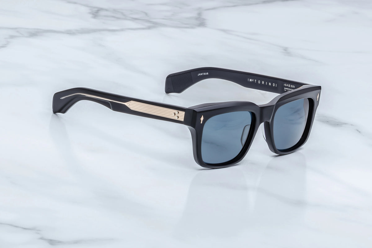 Jacques Marie Mage Torino ’60s-inspired black rectangular sunglasses with light blue lenses and gold-tone metal temple accents, from the Spring 2018 collection.