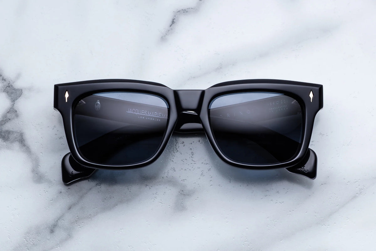 Jacques Marie Mage Torino ’60s-inspired black rectangular sunglasses with thick frames and metal arrow accents on the temples.