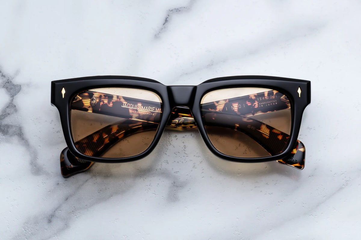 Jacques Marie Mage Torino ’60s-inspired rectangular tortoiseshell sunglasses with black frames and gold-tone rivets, viewed from the front.