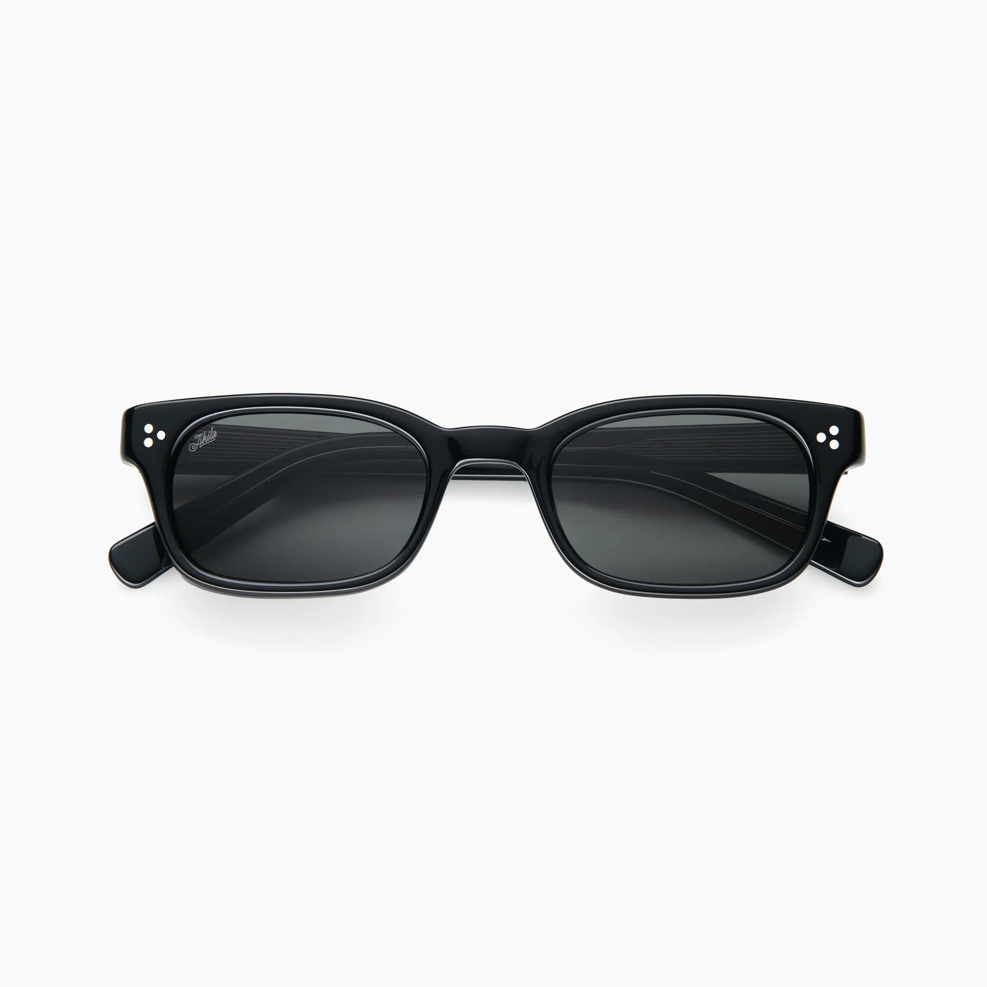 Black rectangular acetate sunglasses with dark grey lenses, white rivet accents, and thick temples, shown front-facing on a white background.