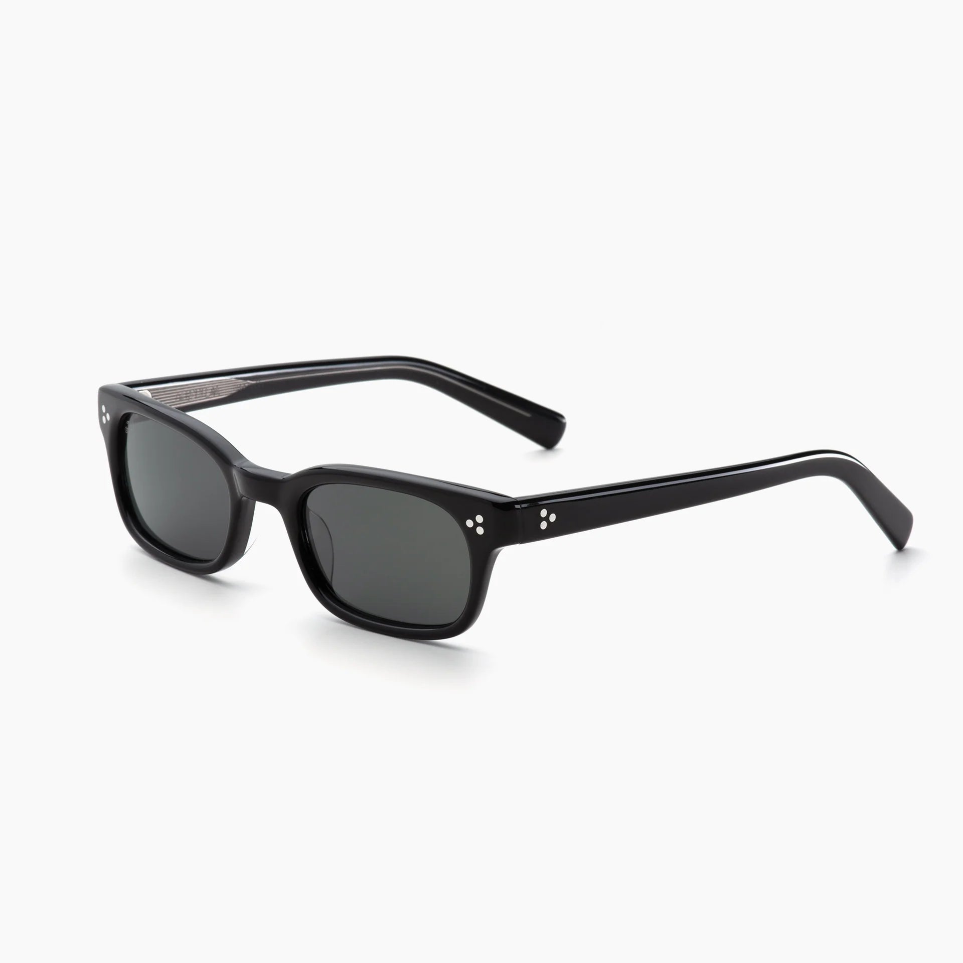Black rectangular acetate sunglasses with dark grey lenses, white rivet accents, and thick temples, shown at an angled side view on a white background.