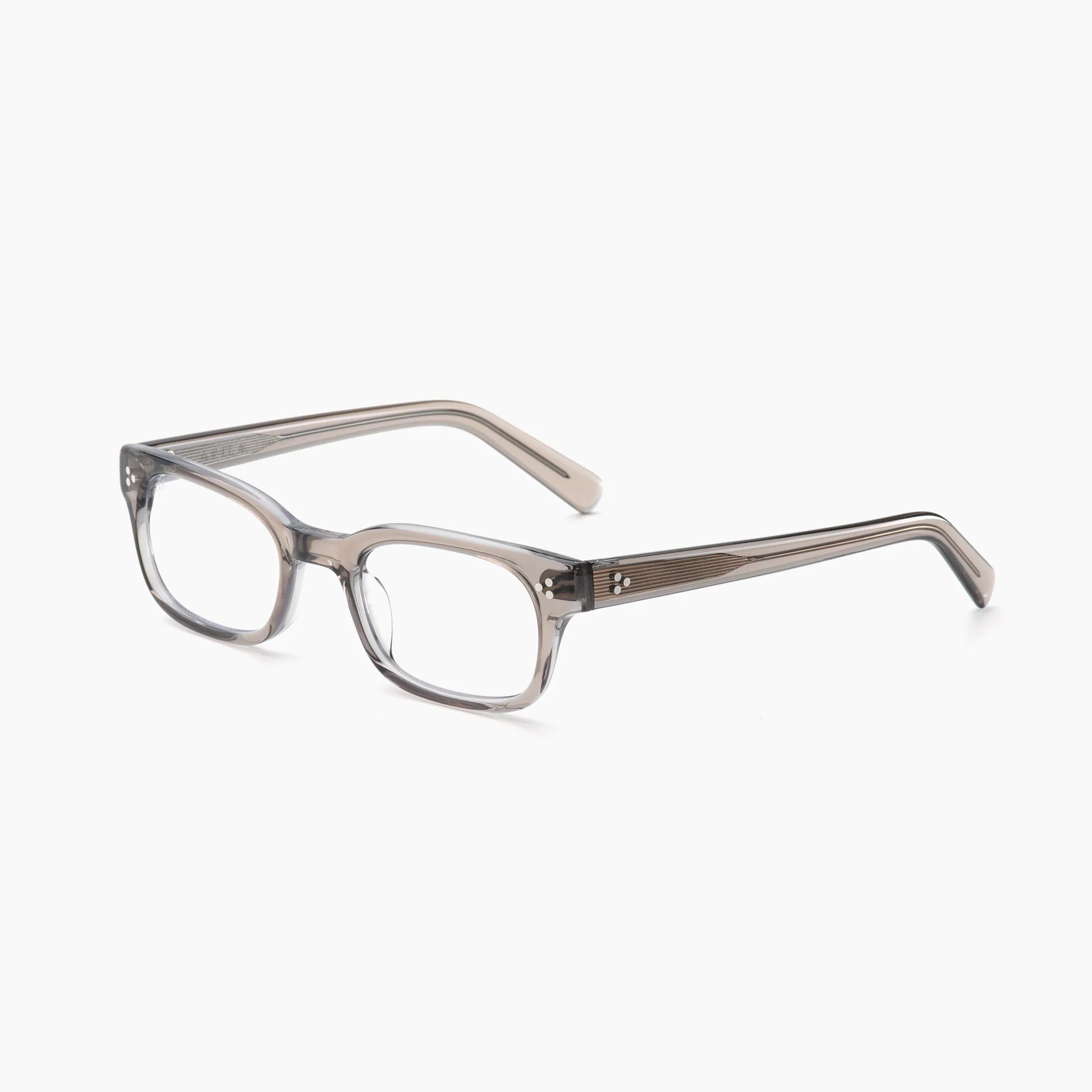 Rectangular Akila Tracer Optical eyeglasses by Akila in clear gray with thick frames and slightly tapered arms, featuring a rectangular design and optional blue light blocking lenses, displayed on a white background at a slight angle.