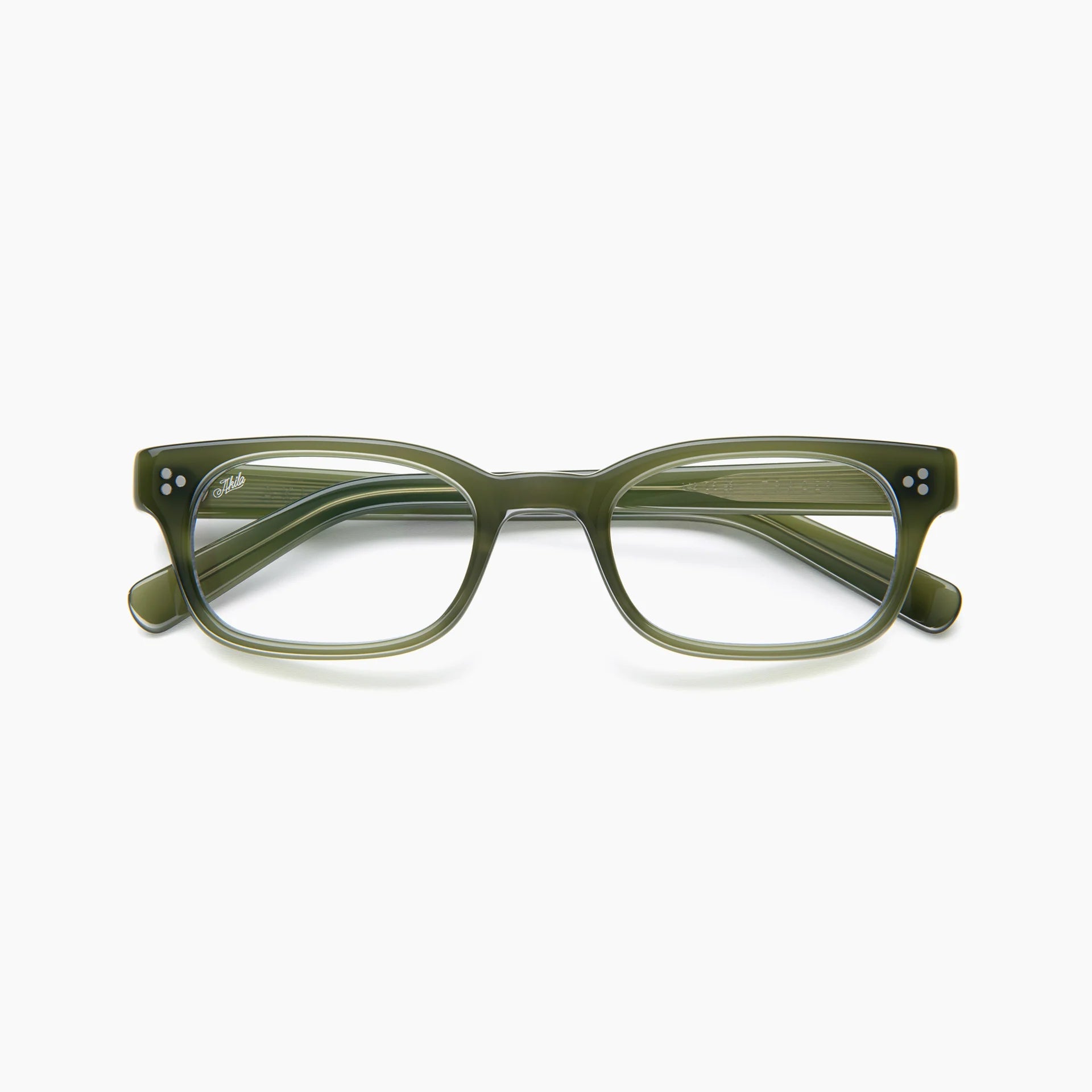 The Akila Tracer by Akila is a signature rectangular eyeglass frame in olive green with a glossy finish, featuring silver rivets on the front corners and straight arms. Optional blue light blocking lenses are available. Shown here against a white background.