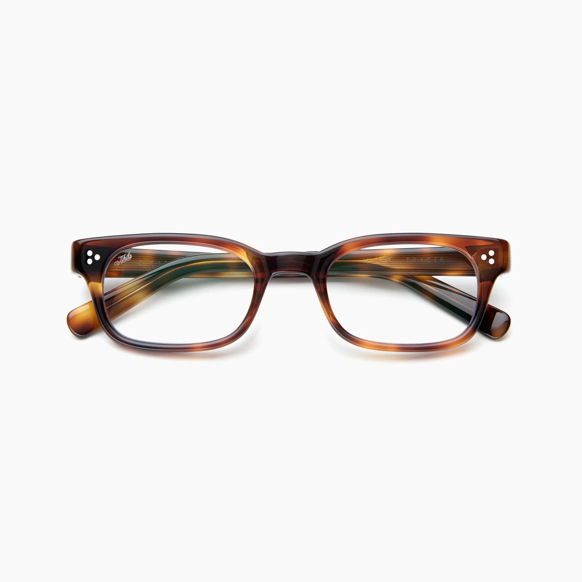 Akila Tracer rectangular eyeglasses featuring a brown tortoiseshell frame with three silver dots on each front corner and clear blue light blocking lenses by Akila, displayed against a plain white background.