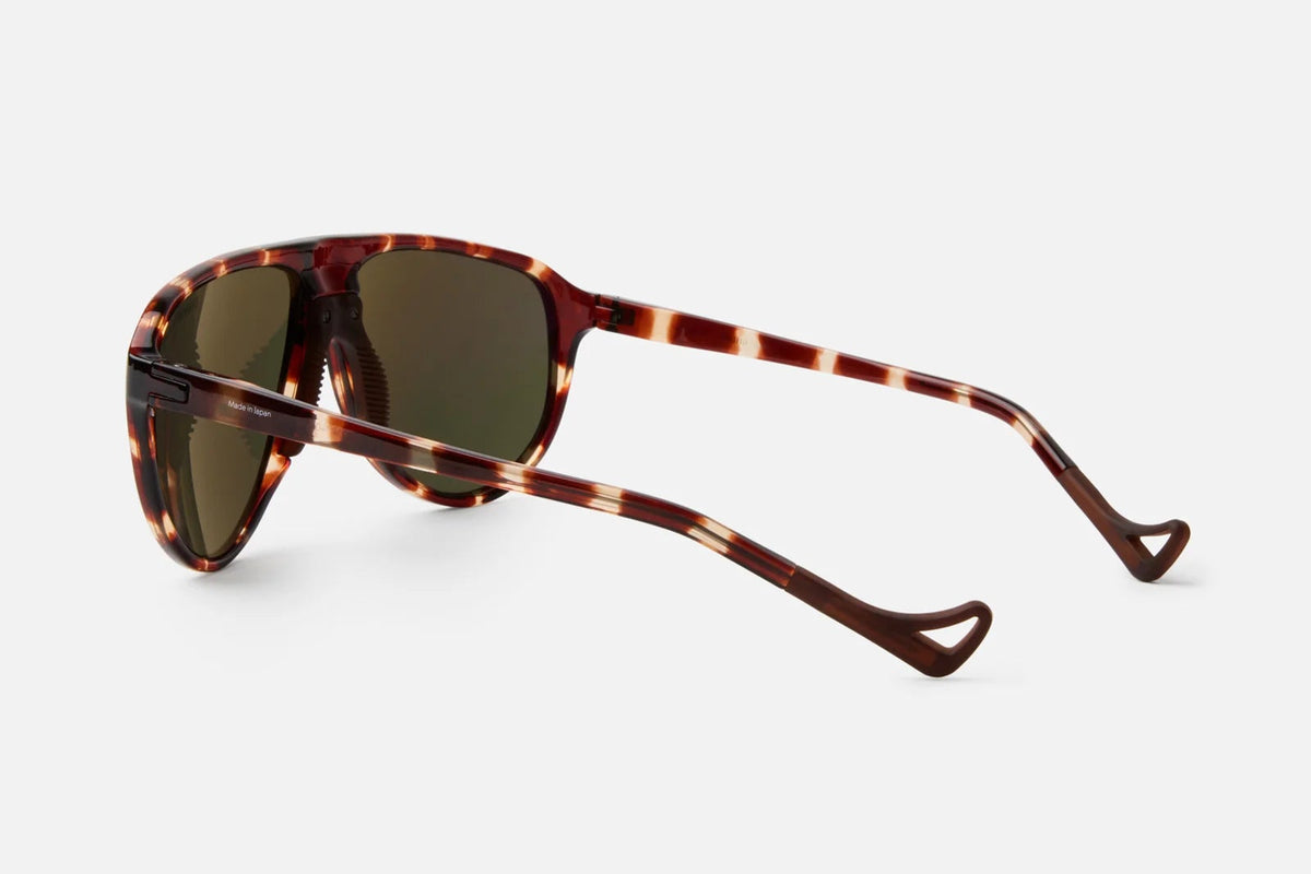 District Vision Yukari Windshield sunglasses featuring a heritage aviator shape, tortoiseshell-patterned frames with dark lenses, and uniquely shaped, looped temple tips.
