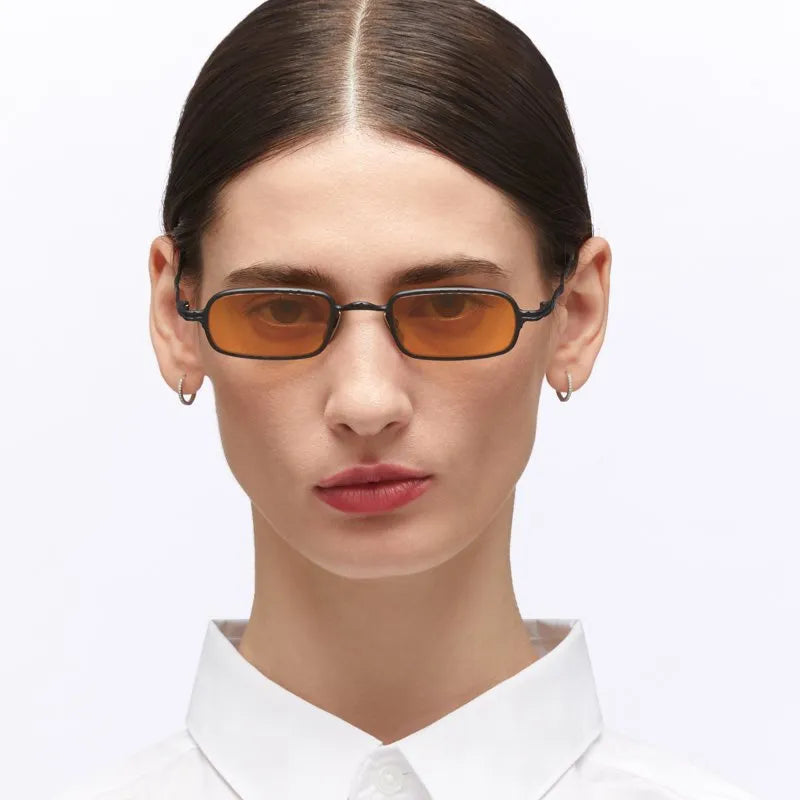 Person wearing a pair of sunglasses with a plain background