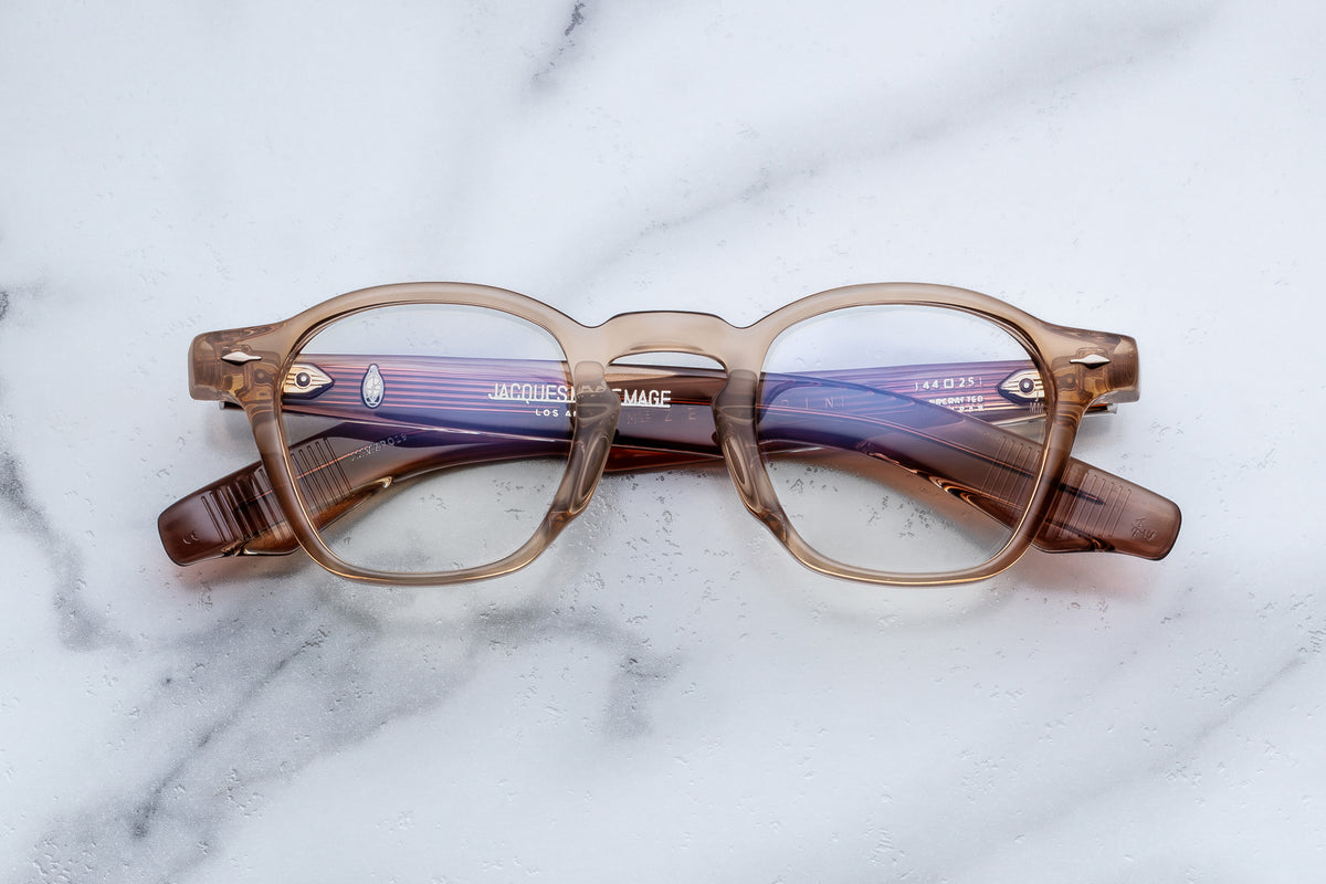 Translucent tan acetate Jacques Marie Mage Zephirin spectacles with rounded rectangular frames and sculpted temples, resting on a white marble surface.