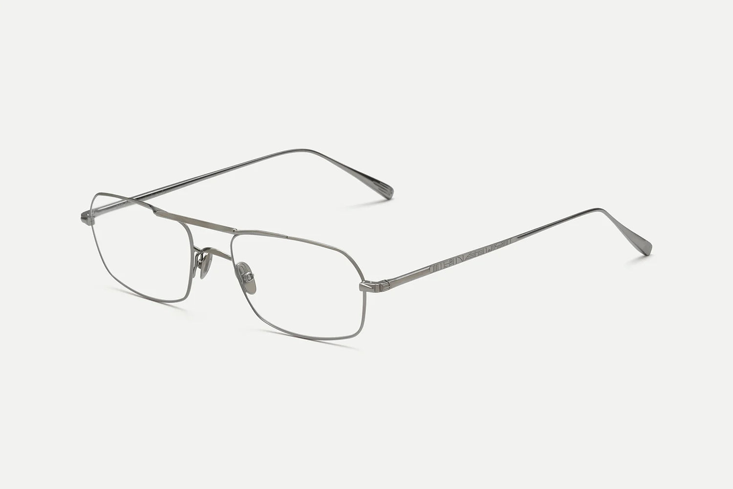 A pair of slim metal eyeglasses with a rectangular frame and thin temples, shown at an angle on a light gray background.