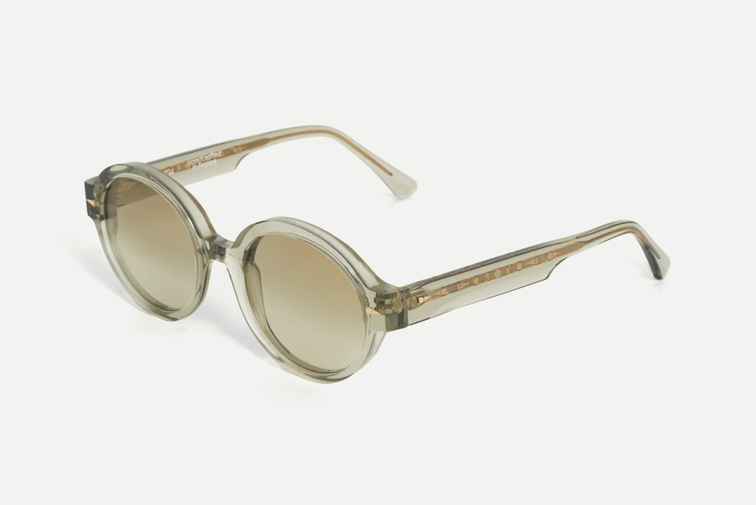 Oversized round sunglasses with translucent smoky gray frames and gradient brown lenses, shown on a light gray background.
