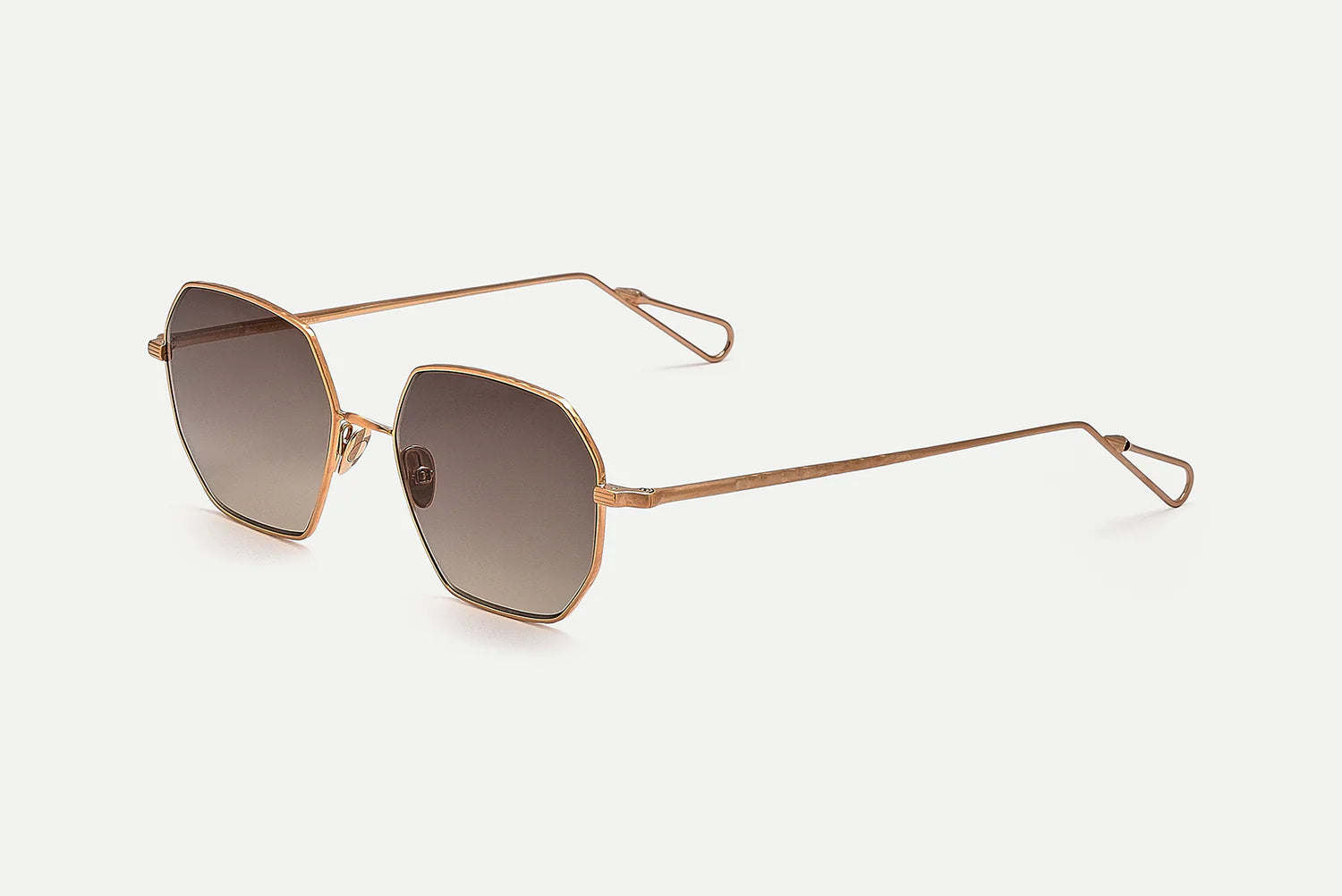 Hexagonal metal-frame sunglasses with gradient brown lenses and slim rose gold temples, shown on a light gray background.