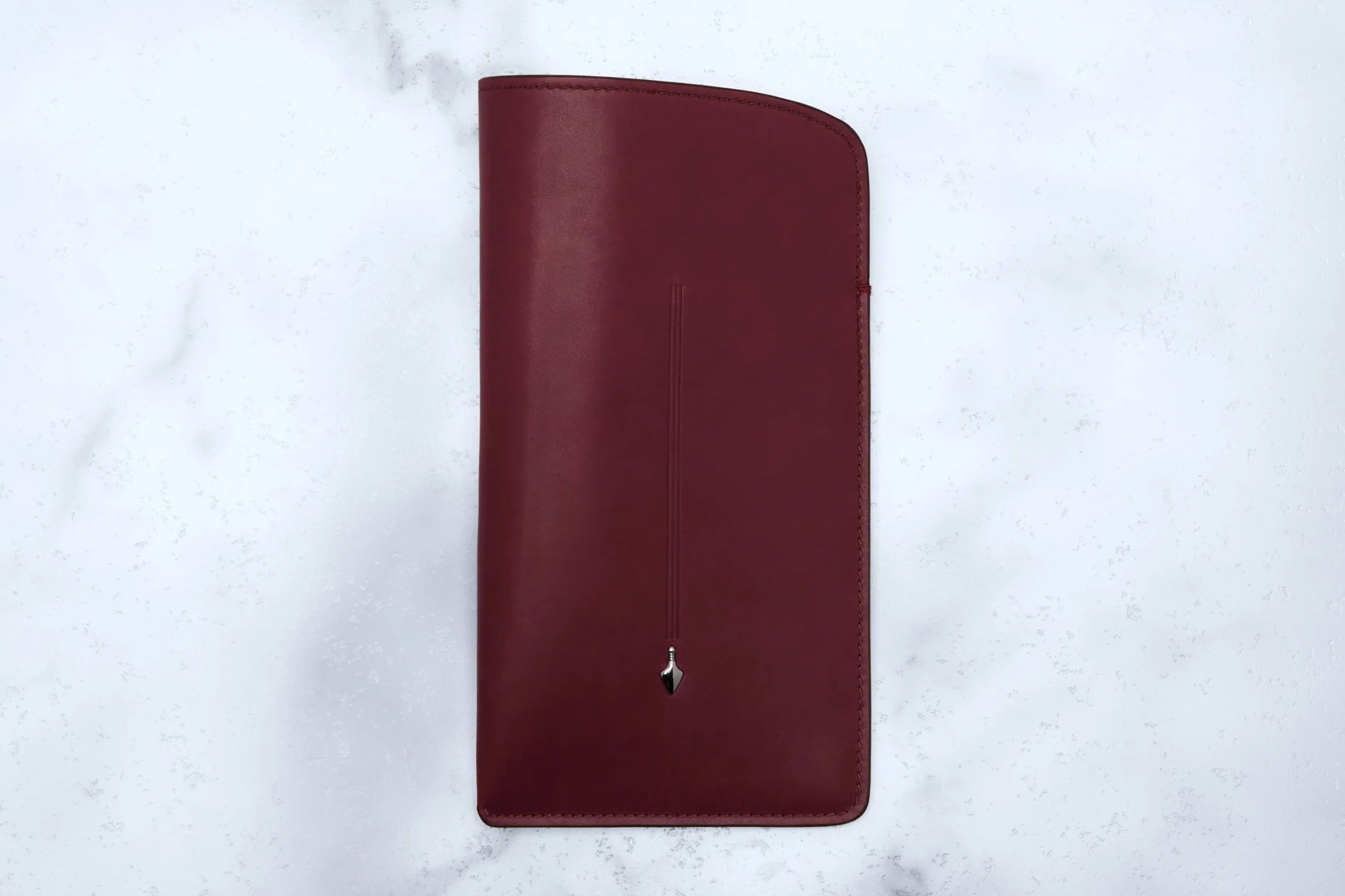 Maroon wallet on a light gray marble background