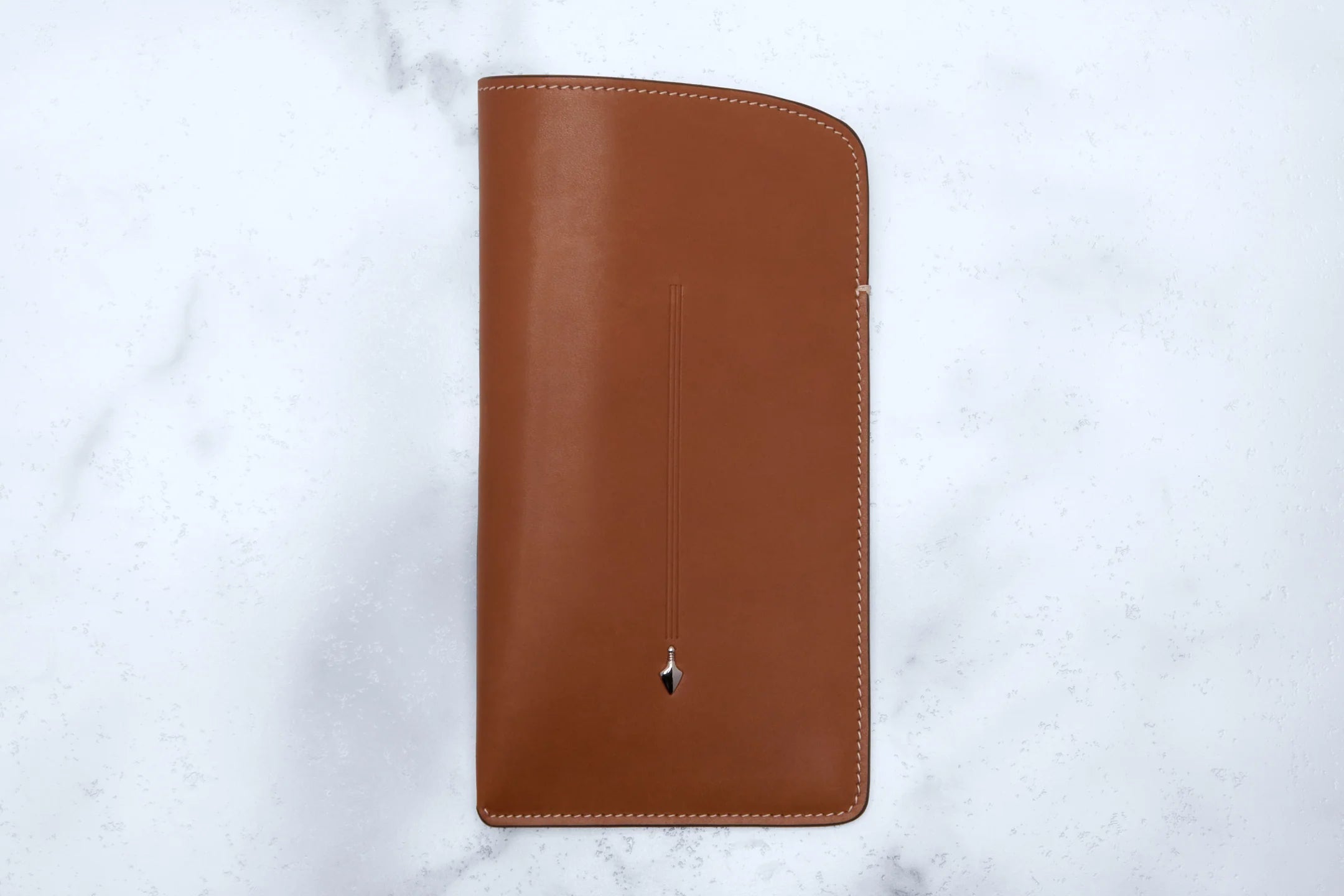 Brown leather wallet on a white marble surface