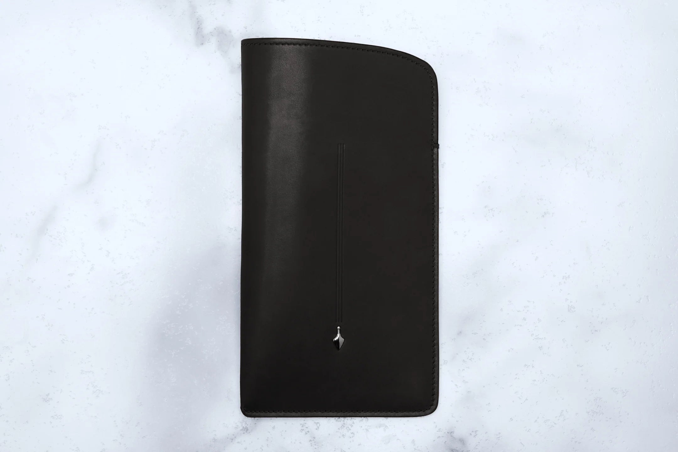 Black leather wallet on a light gray marble background