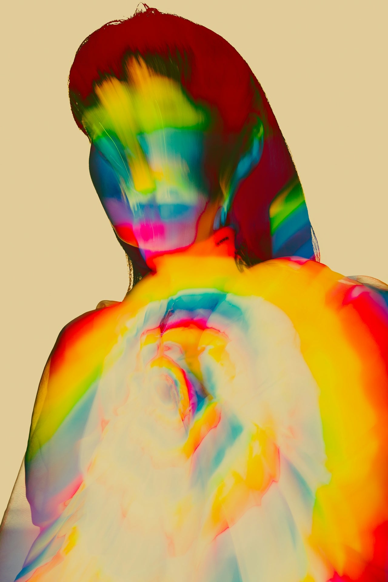 Colorful tie-dye pattern on a person against a beige background