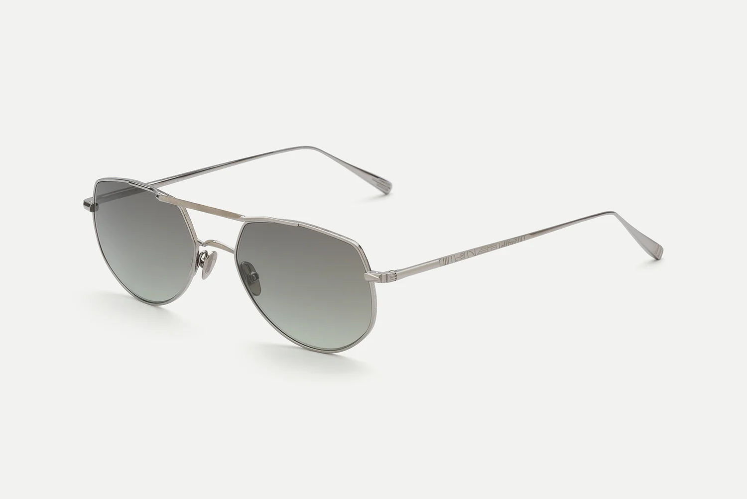 AHLEM Cadet sunglasses by AHLEM—crafted in France—feature silver metal frames with thin arms and round, gradient gray lenses, elegantly showcased against a plain white background.