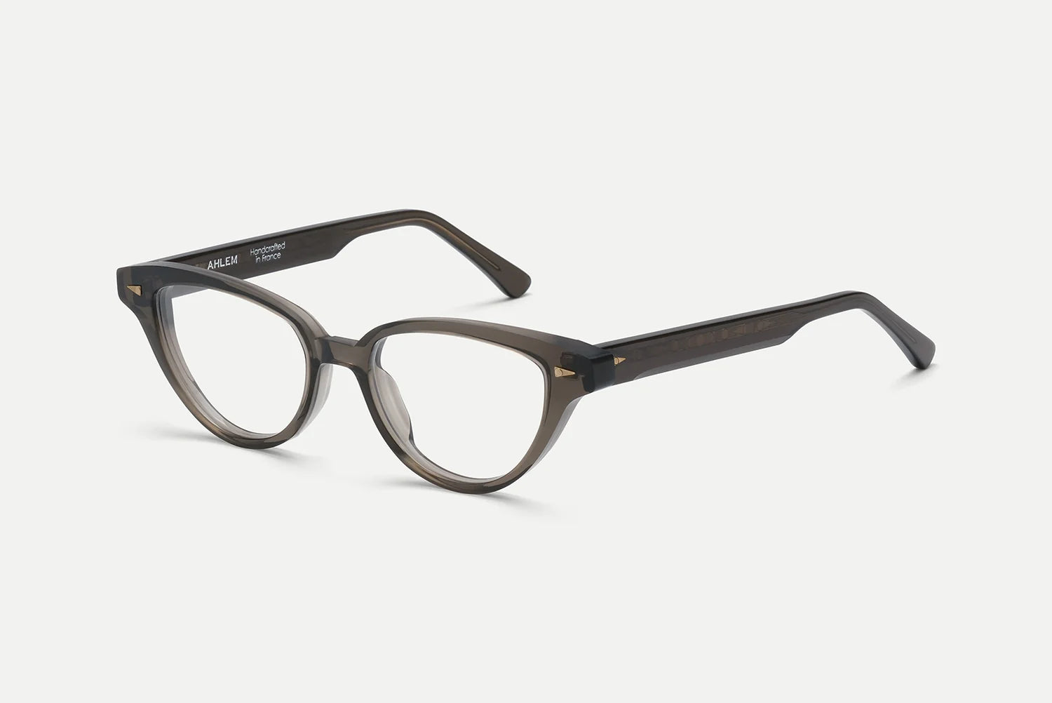 The AHLEM Lilas by AHLEM is a pair of dark, semi-transparent round eyeglasses with thick frames, handcrafted in France from premium plant-based Italian acetate, displayed on a white background.