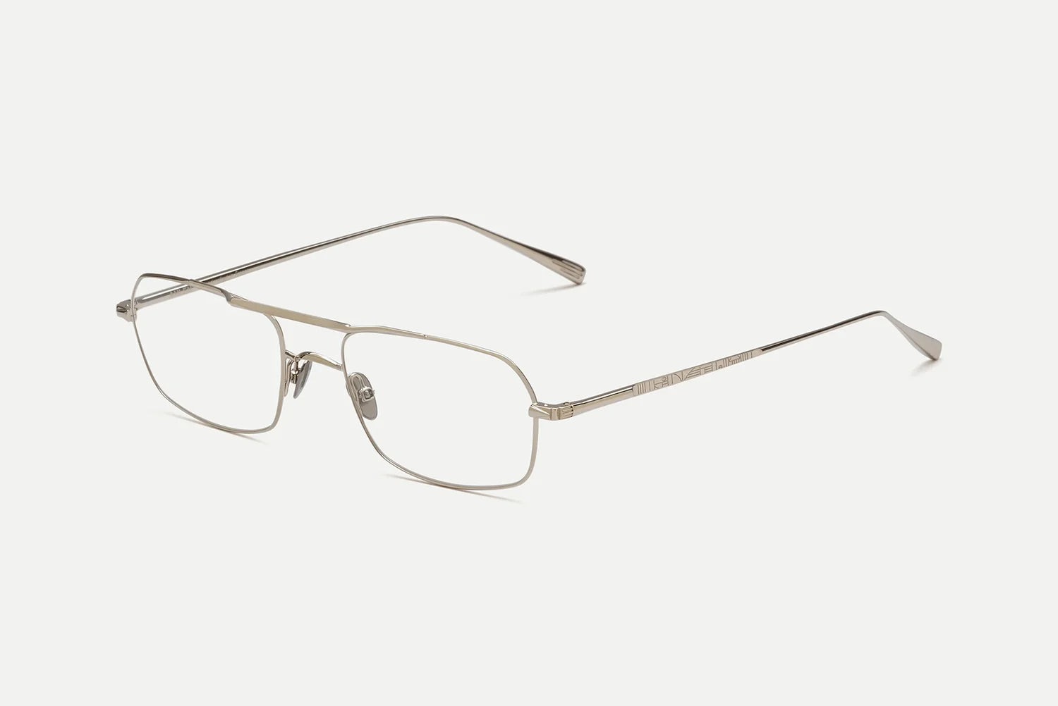 A pair of slim metal eyeglasses with a silver-tone frame and clear lenses, shown at an angle on a light gray background.