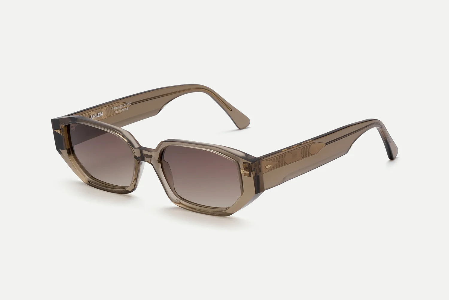 The AHLEM Poitou sunglasses by AHLEM, shown on a white background angled to reveal both the front and side views, feature transparent brown square frames with thick Italian acetate construction, gradient tinted lenses, and a luxurious finish for exceptional durability.