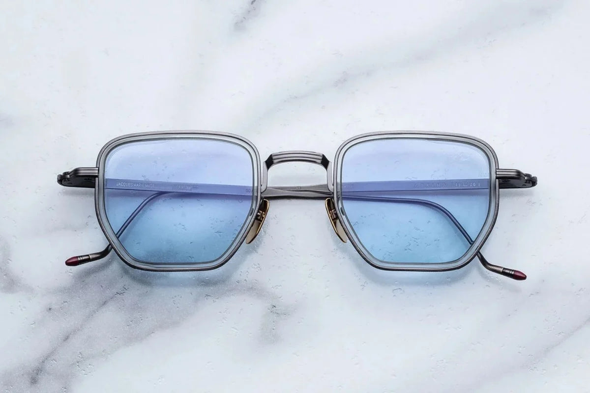Sunglasses with blue lenses on a marble surface