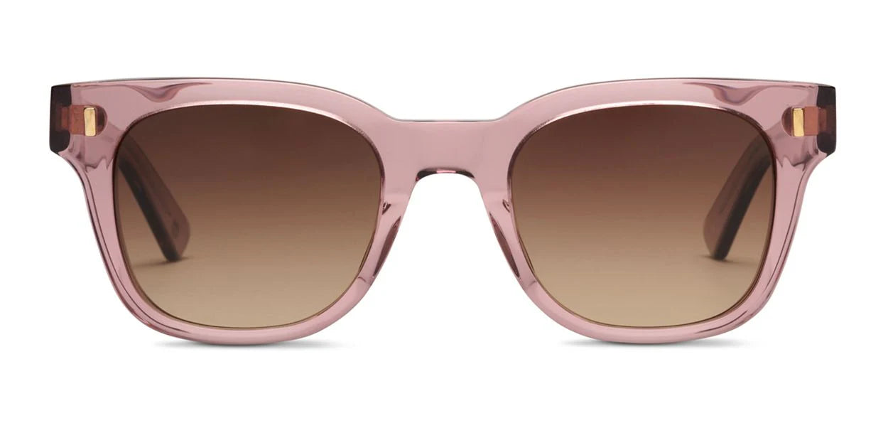 Translucent pink acetate sunglasses with rounded square lenses, brown gradient tint, and gold hinge accents shown front-facing on a white background.