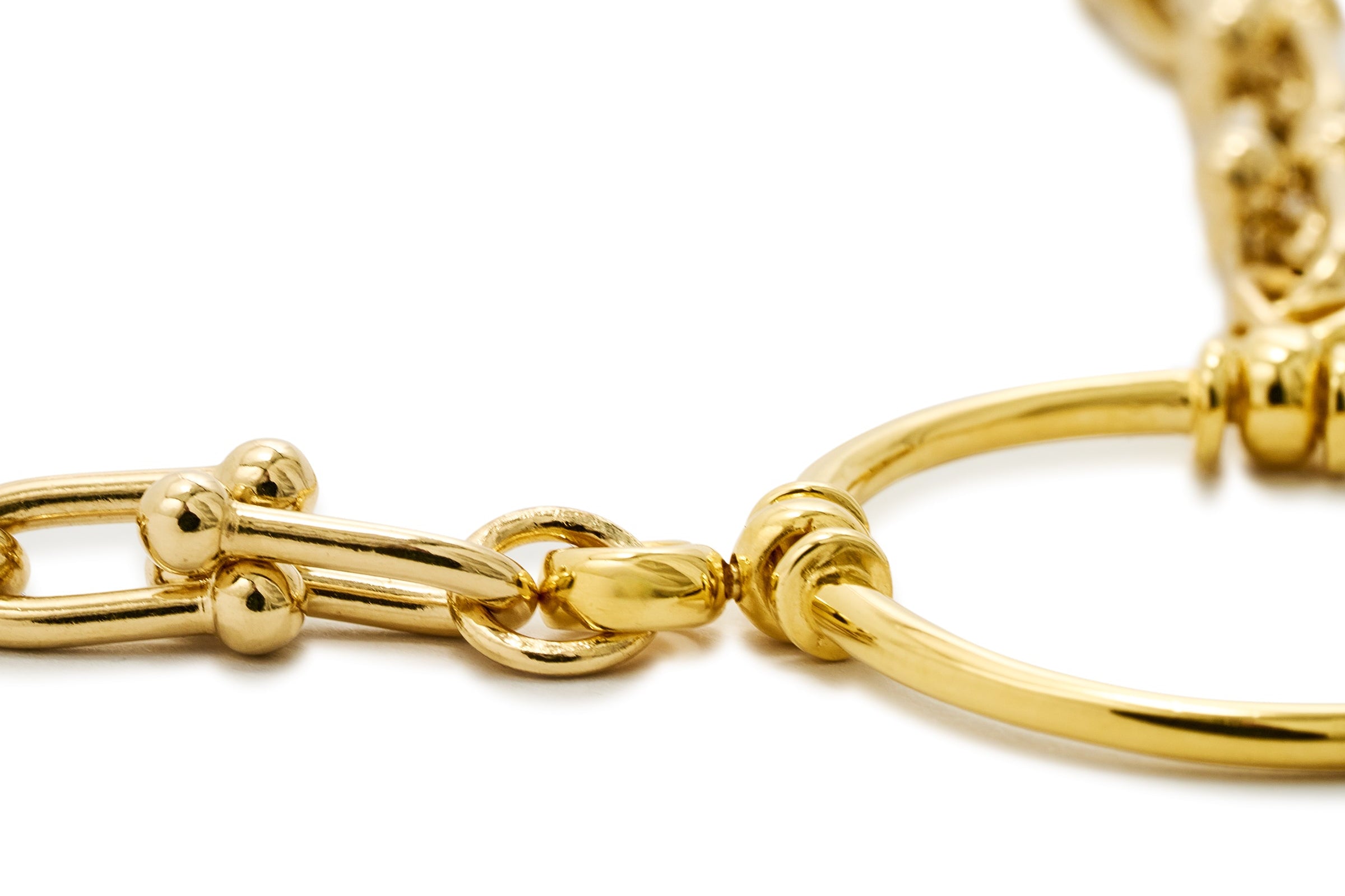 Close-up of a gold chain bracelet on a white background